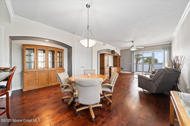 dining room with dark hardwood / wood-style flooring, crown molding, and a textured ceiling