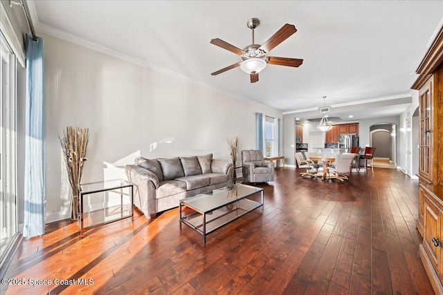 living room with crown molding, dark hardwood / wood-style floors, and ceiling fan