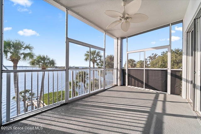 unfurnished sunroom with a water view, a healthy amount of sunlight, and ceiling fan