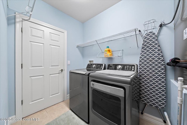 clothes washing area featuring light tile patterned flooring and separate washer and dryer