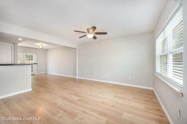 unfurnished living room featuring ceiling fan and light hardwood / wood-style flooring