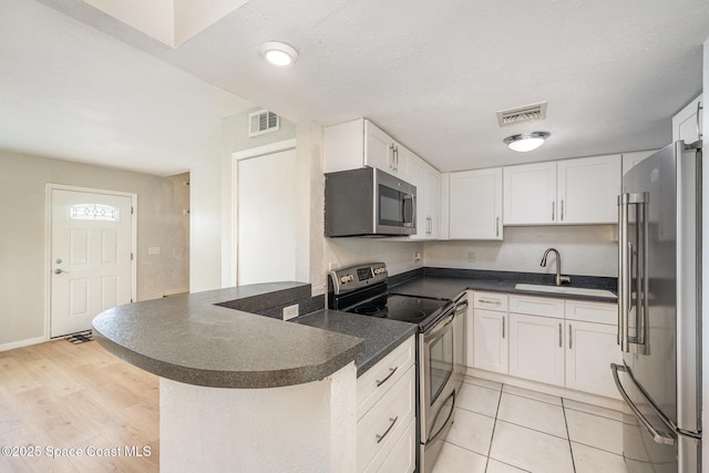 kitchen featuring sink, white cabinets, and appliances with stainless steel finishes