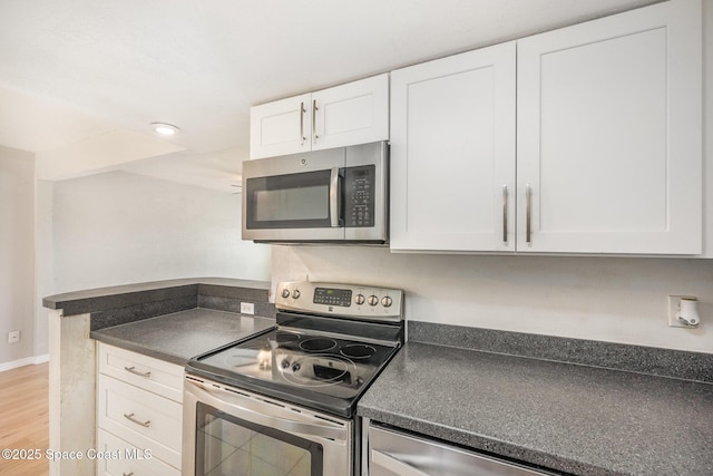 kitchen featuring stainless steel appliances, white cabinets, and light wood-type flooring