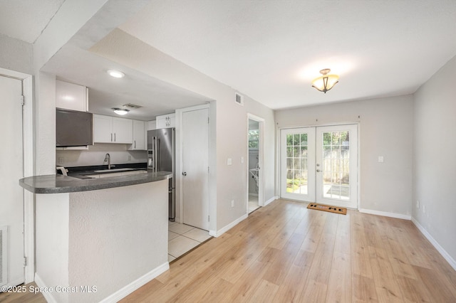 kitchen featuring light hardwood / wood-style flooring, white cabinetry, french doors, high end refrigerator, and kitchen peninsula