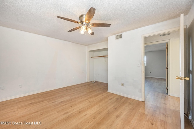 unfurnished bedroom with ceiling fan, a closet, light hardwood / wood-style flooring, and a textured ceiling