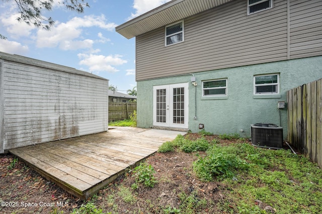 rear view of property with french doors, a deck, and central AC