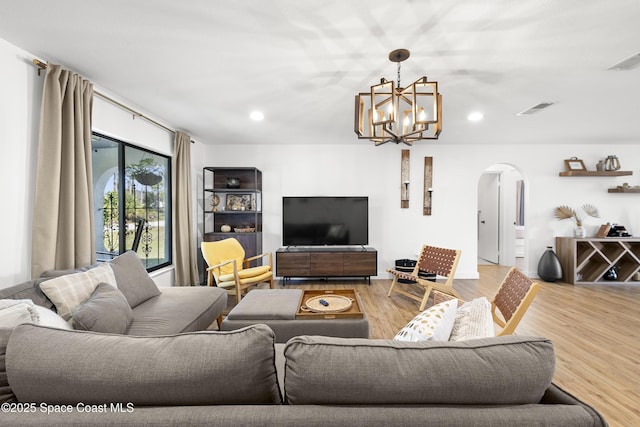 living room with hardwood / wood-style flooring and a notable chandelier