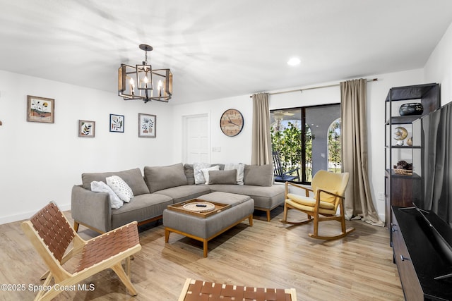 living room featuring an inviting chandelier and light hardwood / wood-style floors