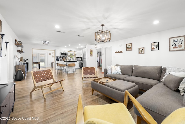 living room featuring a chandelier and light hardwood / wood-style floors