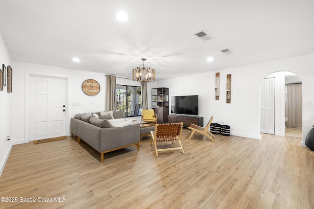 living room featuring a notable chandelier and light hardwood / wood-style floors