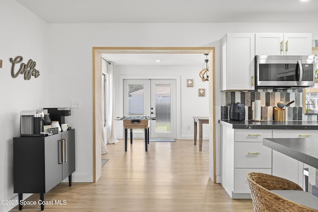 kitchen with tasteful backsplash, white cabinetry, light hardwood / wood-style floors, and french doors