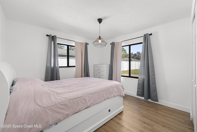 bedroom with hardwood / wood-style floors and a textured ceiling