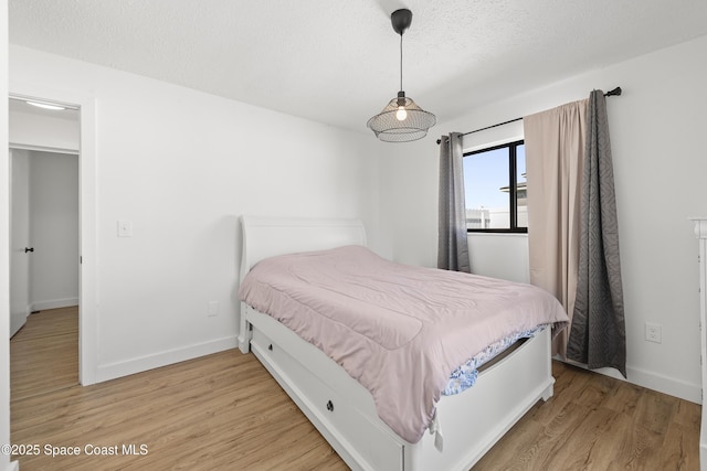 bedroom with hardwood / wood-style floors and a textured ceiling