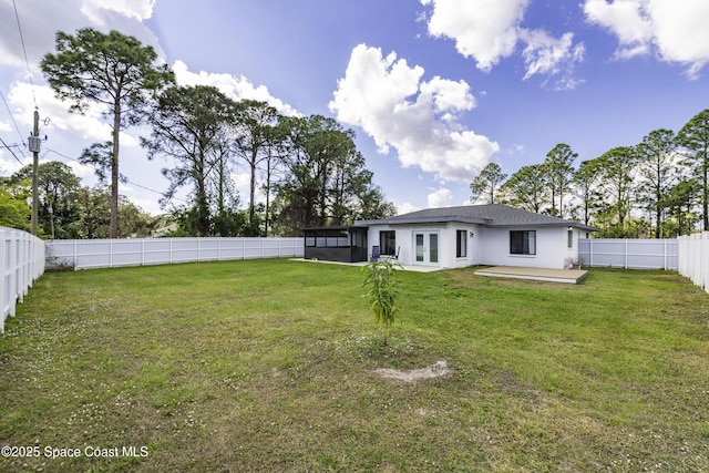 rear view of property featuring a sunroom and a lawn