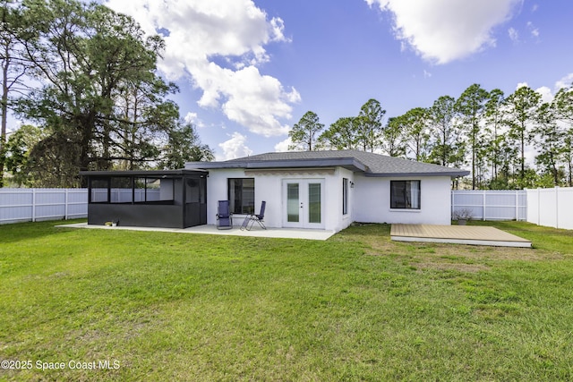 rear view of property featuring french doors, a yard, a deck, and a sunroom