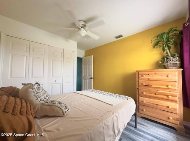 bedroom featuring dark hardwood / wood-style floors, a closet, and ceiling fan