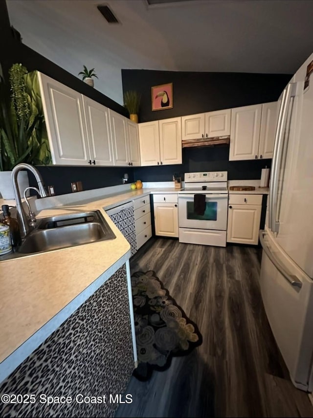 kitchen featuring lofted ceiling, sink, white cabinets, dark wood-type flooring, and white appliances