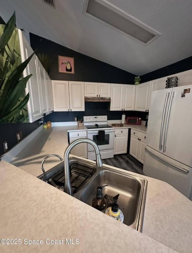 kitchen featuring vaulted ceiling, white appliances, sink, and white cabinets