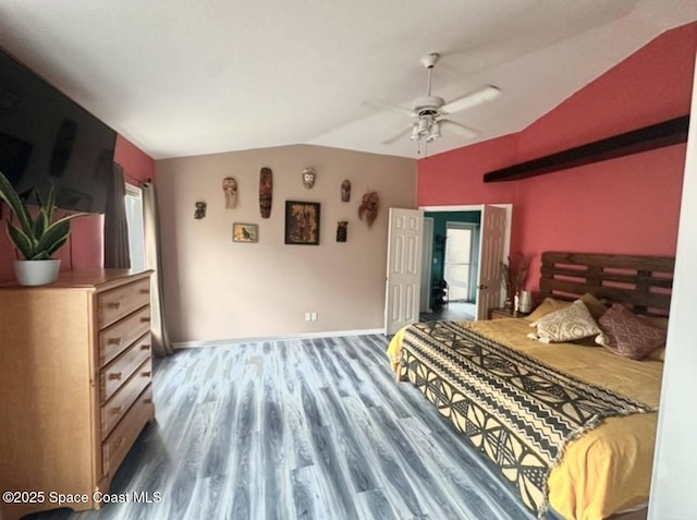 bedroom featuring wood finished floors, a ceiling fan, baseboards, and vaulted ceiling