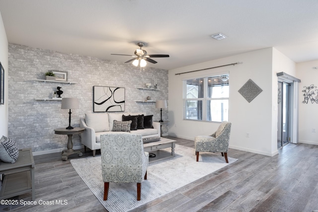 living room featuring ceiling fan and hardwood / wood-style floors