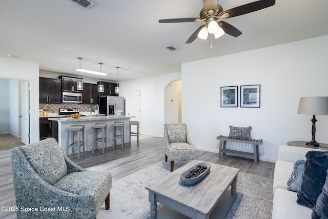 living room with ceiling fan and light wood-type flooring