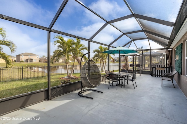 sunroom / solarium featuring a water view and vaulted ceiling