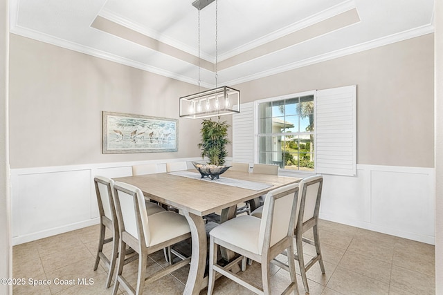 dining space with a raised ceiling, ornamental molding, and light tile patterned floors