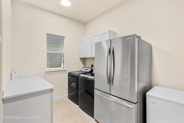 kitchen with independent washer and dryer, stainless steel fridge, and white cabinets