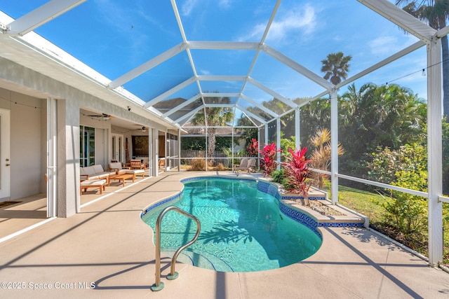 view of pool featuring ceiling fan, glass enclosure, a patio area, an outdoor hangout area, and pool water feature