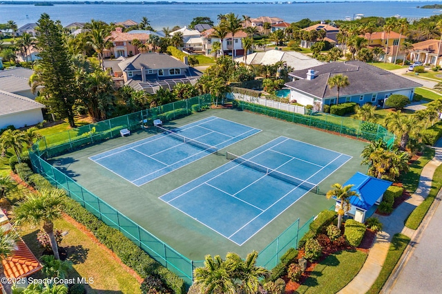 view of tennis court with a water view