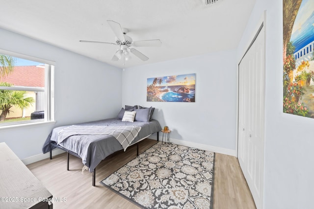 bedroom featuring ceiling fan, a closet, and light hardwood / wood-style flooring