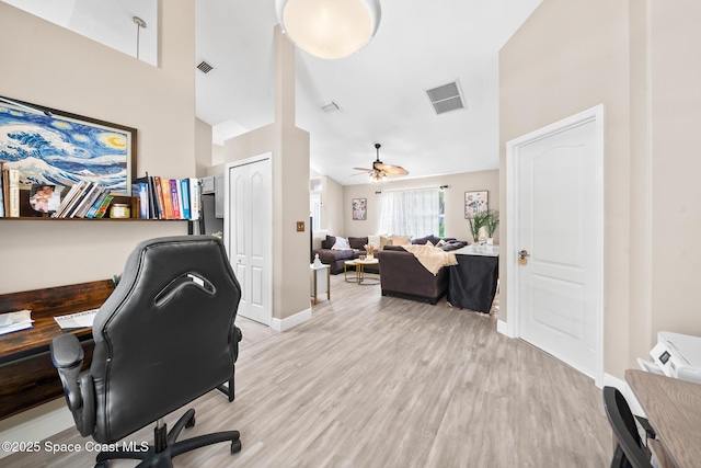 office area with light hardwood / wood-style flooring, high vaulted ceiling, and ceiling fan