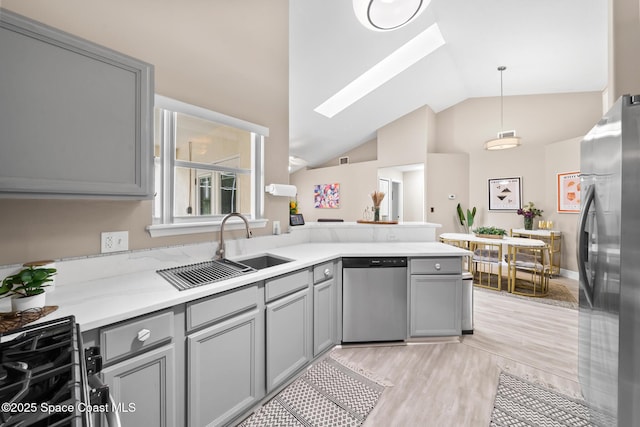 kitchen featuring pendant lighting, sink, gray cabinets, and stainless steel appliances