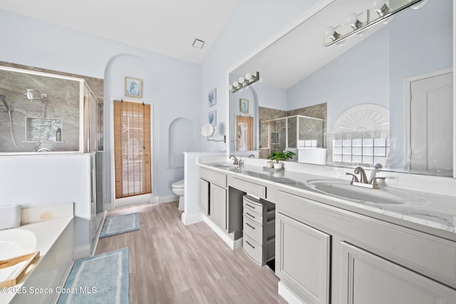 full bathroom featuring lofted ceiling, hardwood / wood-style flooring, vanity, shower with separate bathtub, and toilet