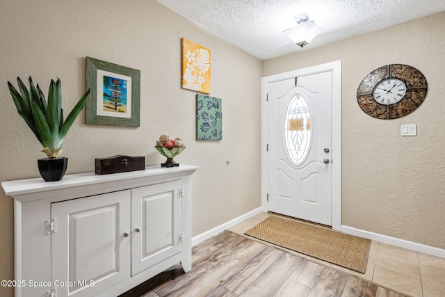 entryway with wood-type flooring and a textured ceiling