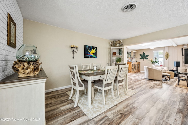 dining room featuring hardwood / wood-style floors and a textured ceiling