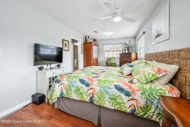 bedroom with hardwood / wood-style flooring, a textured ceiling, and ceiling fan