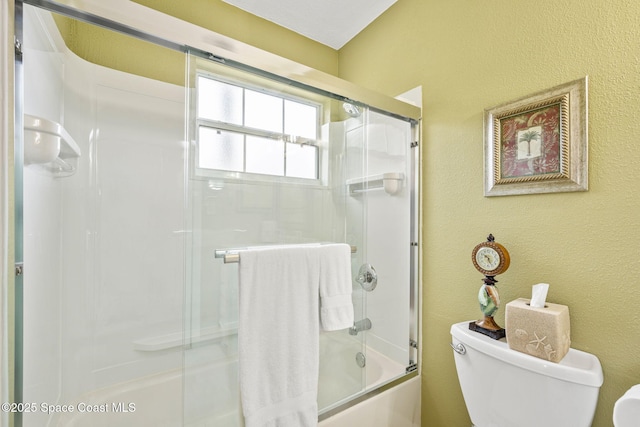 bathroom featuring shower / bath combination with glass door and toilet