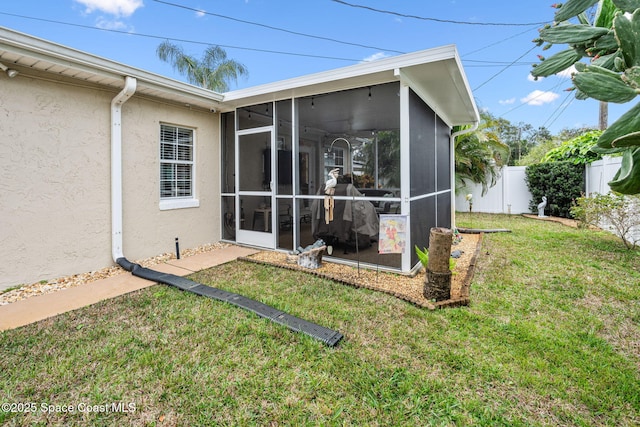 back of house with a sunroom and a yard