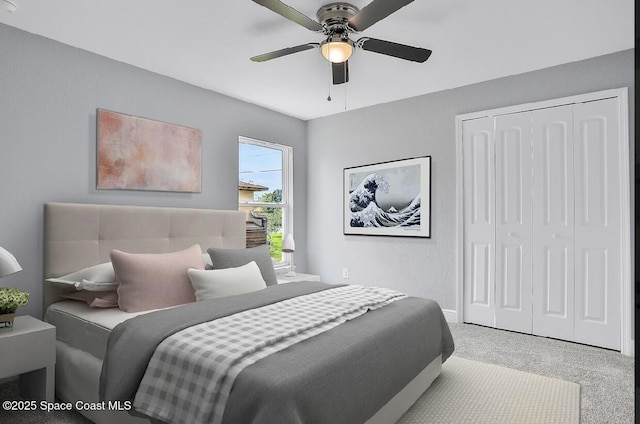 carpeted bedroom featuring ceiling fan and a closet