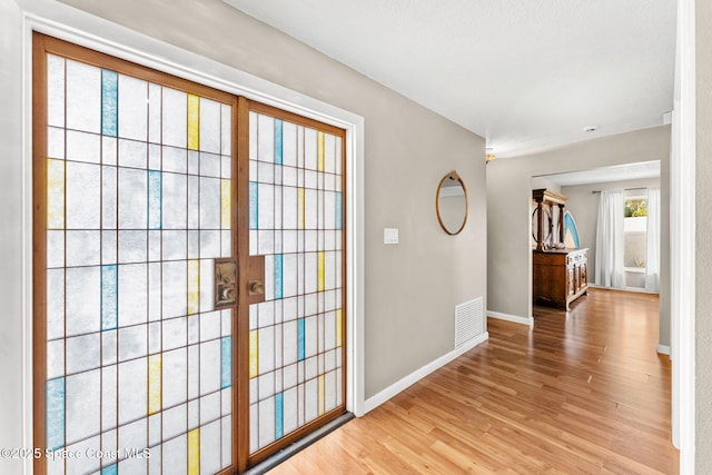 interior space with visible vents, light wood-type flooring, and baseboards