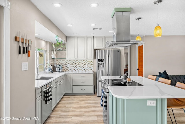 kitchen with tasteful backsplash, a breakfast bar area, island range hood, stainless steel appliances, and a sink