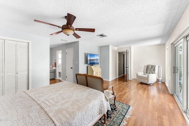 bedroom featuring visible vents, light wood-style flooring, a ceiling fan, a textured ceiling, and baseboards