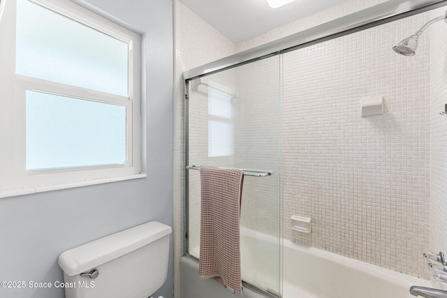 bathroom featuring shower / bath combination with glass door and toilet