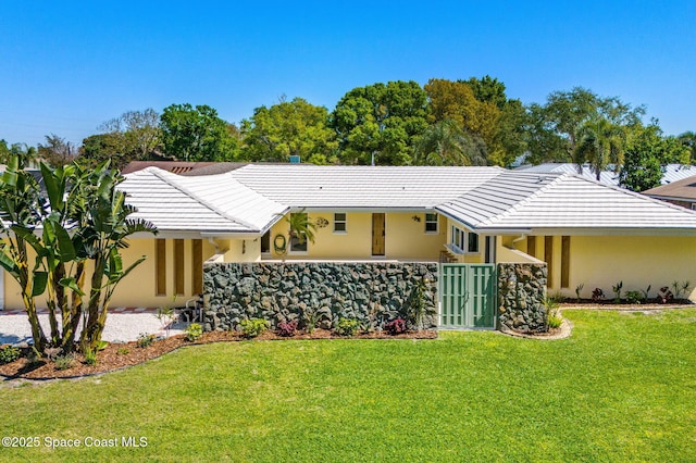 view of front of home with stucco siding, a front lawn, and fence