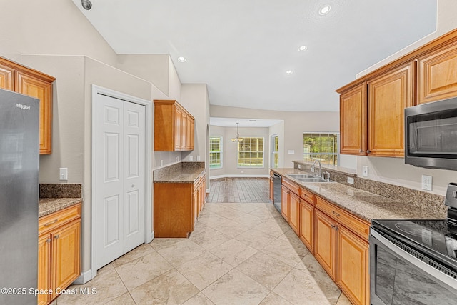 kitchen with stainless steel appliances, lofted ceiling, sink, and dark stone countertops