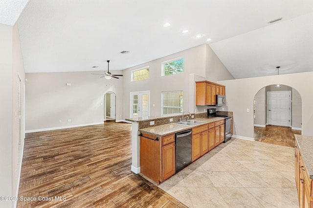 kitchen featuring black appliances, sink, ceiling fan, kitchen peninsula, and light wood-type flooring