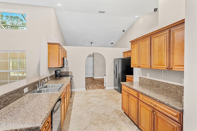 kitchen featuring high vaulted ceiling, dark stone counters, sink, and black appliances