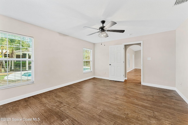 spare room featuring a textured ceiling, wood-type flooring, and ceiling fan