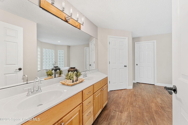 bathroom with vanity, hardwood / wood-style flooring, and a textured ceiling